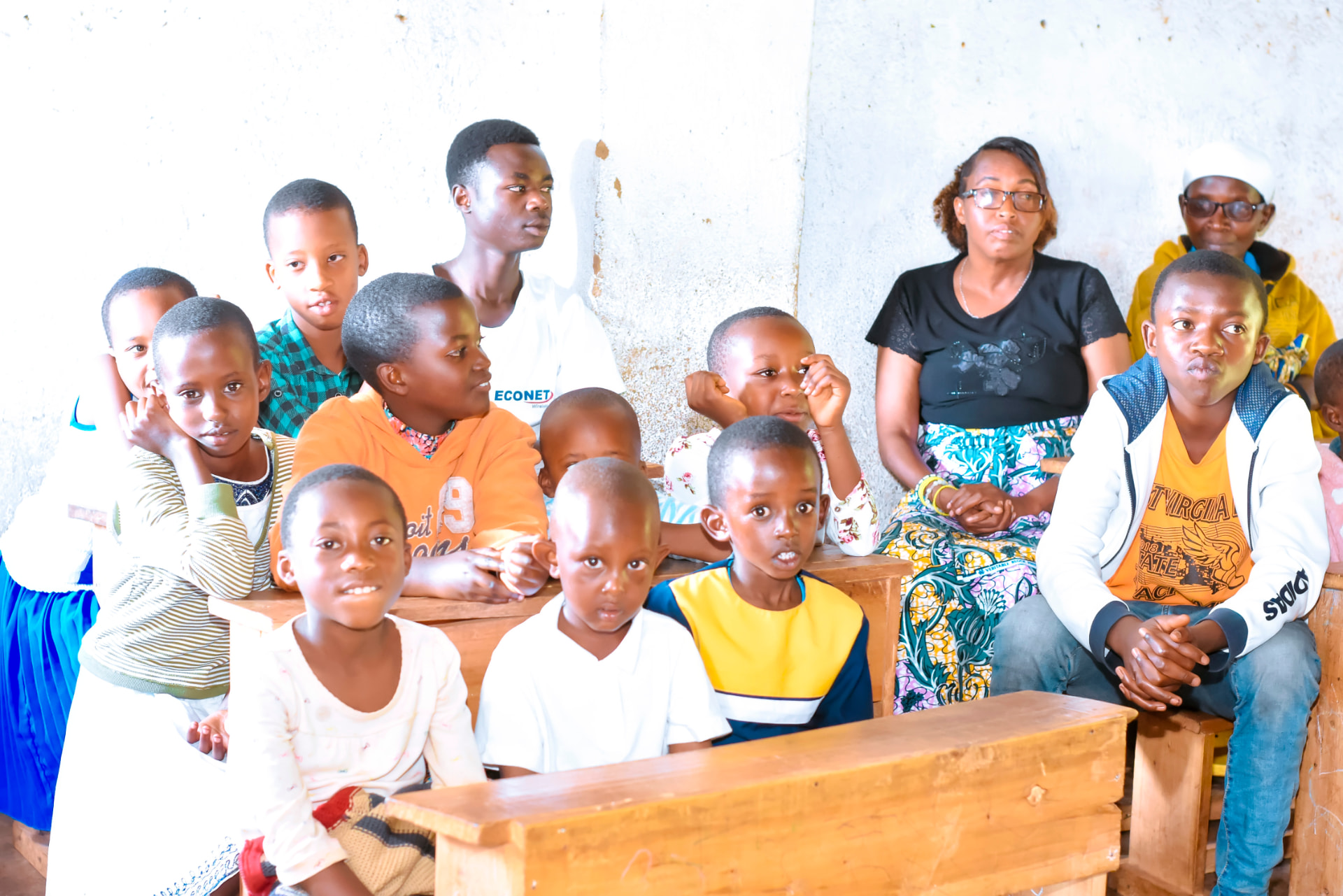 Children, teachers and parents listening together during a session.