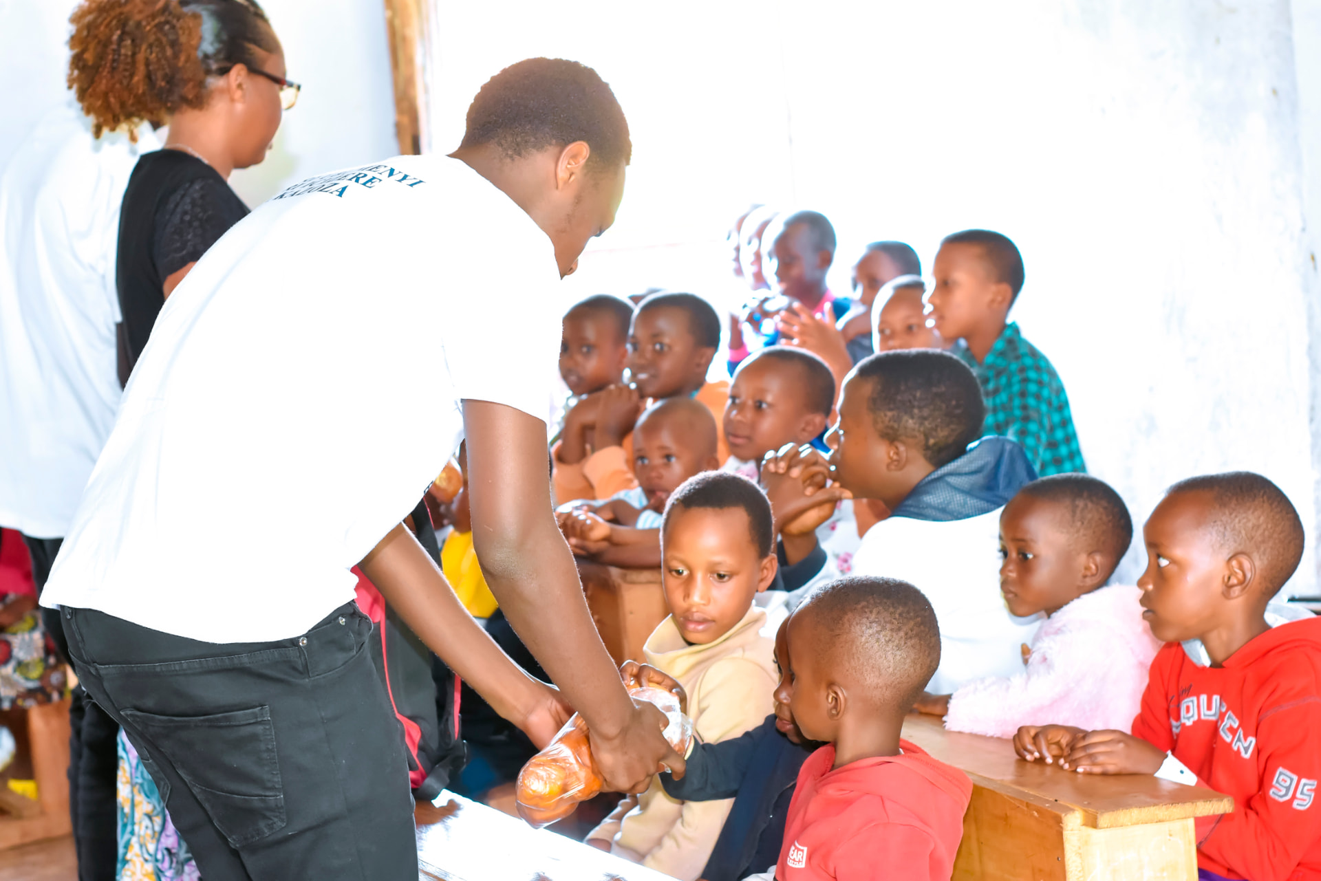 A volunteer sharing refreshments with the children during a visit.