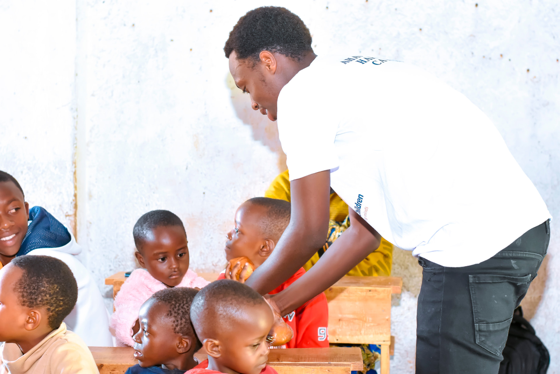 A volunteer greeting a child, one by one, during a distribution.