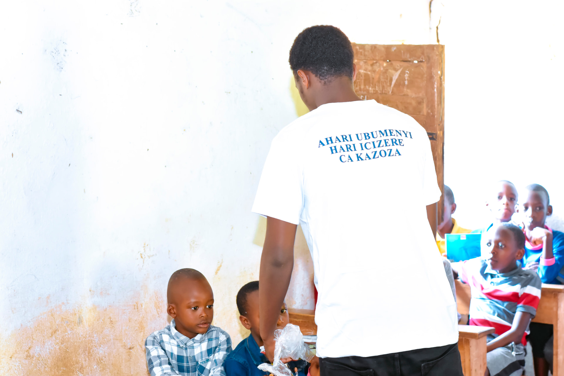 A child in Burundi holding exercise books received during a school visit.